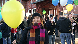 Frau mit Luftballon vor Gruppe; Link zur Seite des Luftballonwettbewerbs