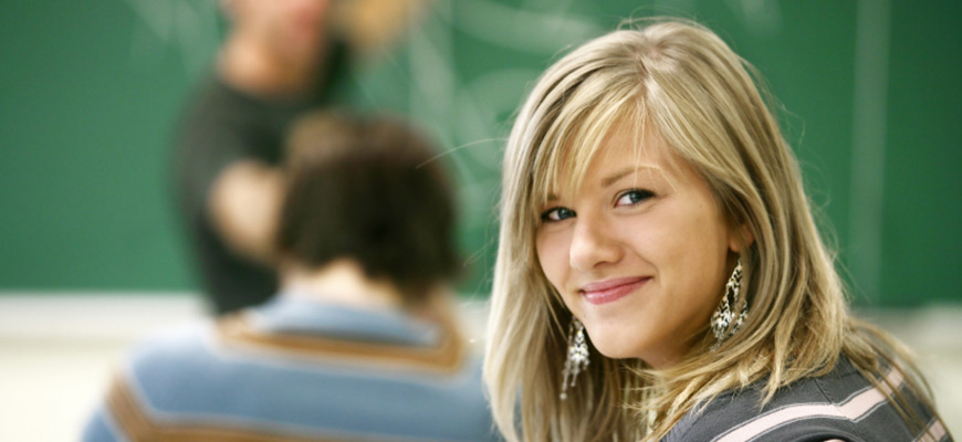 Eine Schülerin blickt über ihre Schulter in die Kamera.